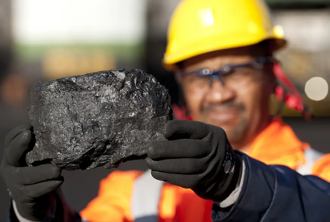 Richard Mokwena holds up a piece of coal from the 4 seam which is being mined at ramp 51 at Anglo American Thermal Coal - Kriel Colliery. © Anglo American