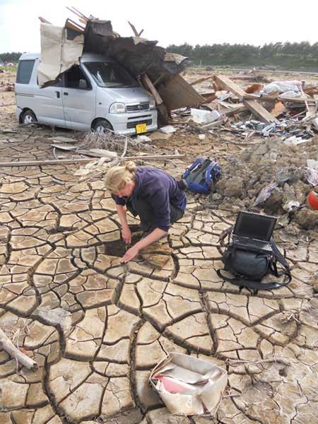 Hannah Evans digging holes to analyse tsunami sediments.