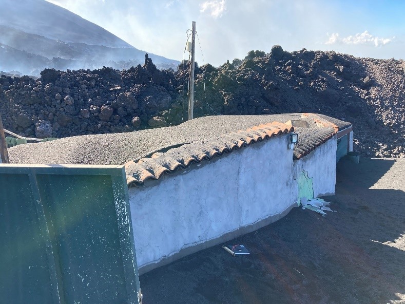 A huge pile of blocky a'a lava approached a small white building