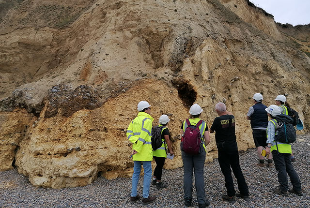 Examining the glacial sediments exposed in the cliffs at Happisburgh. Sarah Arkley, BGS © UKRI.