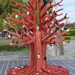 A wooden tree sculpture adorned with items from modern life. Commoditree BGS © UKRI.