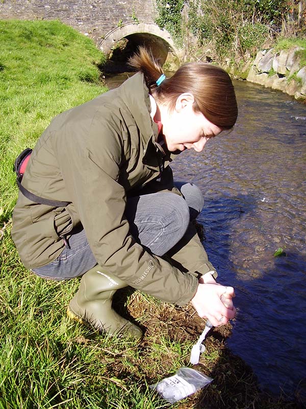 A woman taking samples from a stream