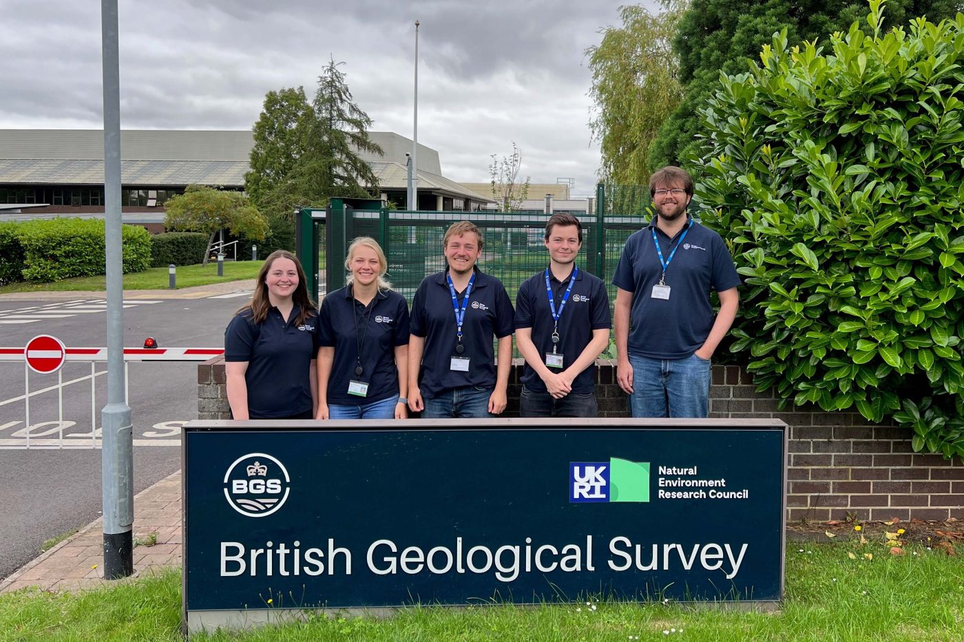 Five students stand behind a sign for the British Geological Survey