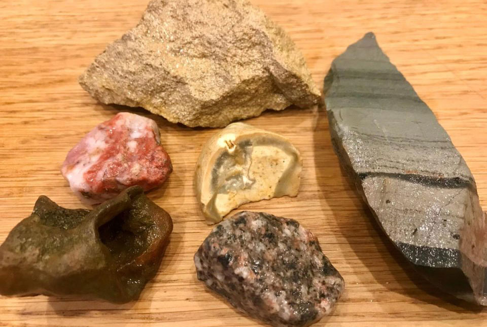 Fragments of rocks found around Rutland Water, the oolitic limestone is at the top, a green-grey stripy volcanic rock is to the right, then chert (white), quartz (red), ironstone (brown) and granite (grey, white, black, pink). Source: BGS © UKRI